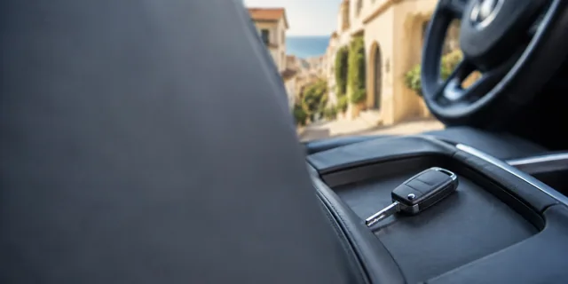 Remote car key resting in a charcoal vehicle centre console